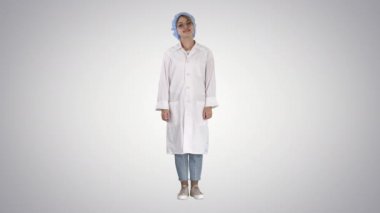 Elleri kalçada olan, ayakta duran, gevşemiş ve gülümseyen, çok olumlu ve neşeli bir kadın..