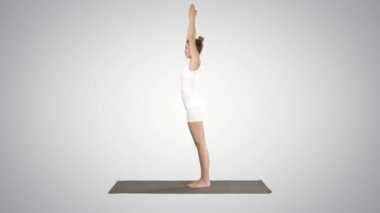 Güzel genç kadın ayak bileği, buzağı, uyluk, kalça ve omuzlar, Eagle Pose, Garudasana degrade arka planda Yoga egzersiz yapıyor.