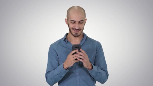 Hombre casual usando la escritura del teléfono inteligente de la célula Mensaje en el fondo del gradiente . — Vídeos de Stock