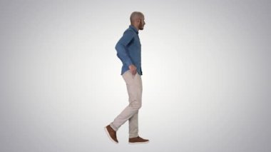 Model modelinden emin, elleri cebinde gradyan arka planda yürüyor..