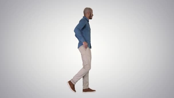 Vertrouwen in zijn stijl model walkin met de handen in zakken op gradiënt achtergrond. — Stockvideo