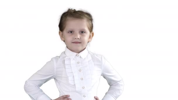 Carino bambina in abito bianco in posa sulla macchina fotografica su sfondo bianco . — Video Stock