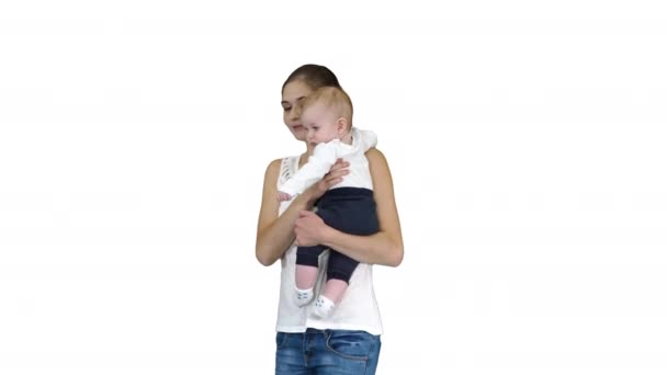Young mother making an attention gesture while holding her baby on white background. — Stock Video