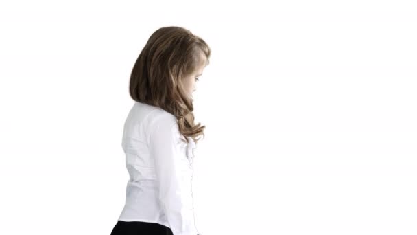 Little girl with long hair walking and looking down on white background. — Stock Video