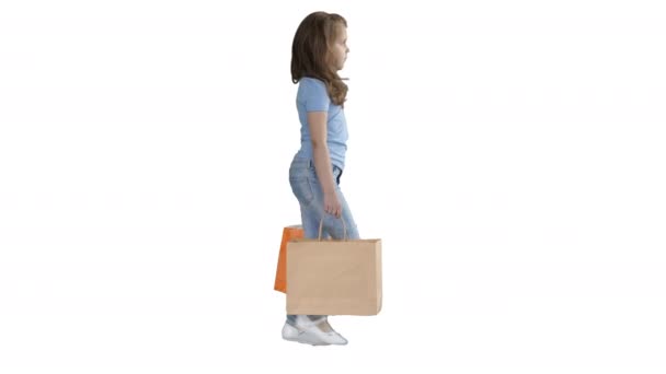 Allegro scuola ragazza a piedi con shopping bags su sfondo bianco . — Video Stock