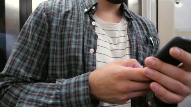 Mężczyzna korzystający z telefonu komórkowego w pociągu metra. — Wideo stockowe