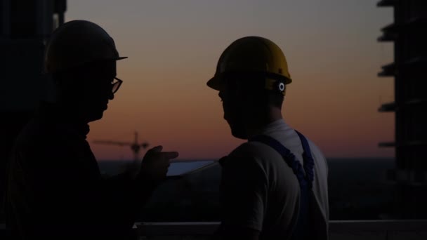 Byggnadsarbetare som använder digitala surfplattor vid solnedgången. — Stockvideo