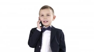 Akıllı telefonuyla konuşan sevimli küçük bir çocuk ve beyaz arka planda koyu renk bir takım elbise içinde duruyor..