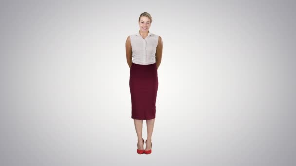 Atrakcyjna nieśmiała bizneswoman stojąca i patrząca w kamerę na gradientowym tle. — Wideo stockowe