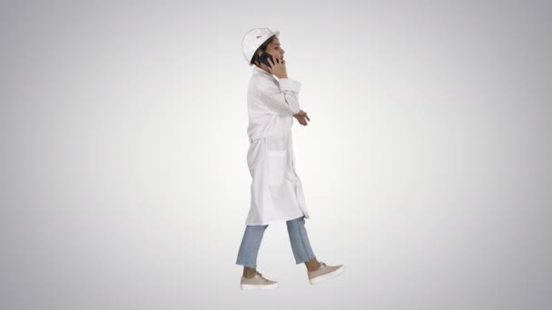 Female scientist making a call walking on gradient background. — Stock Video