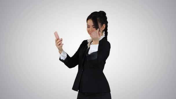 Mujer de negocios mirar en el teléfono inteligente preening y bailando en el fondo gradiente . — Vídeos de Stock