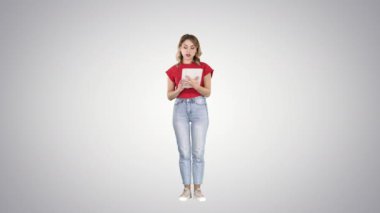 Tablette okuyan ve degrade arka planda kameraya konuşan kadın.