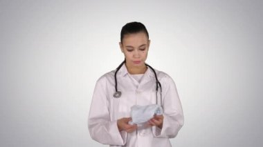 Steteskoplu bir tıp doktoru gradyan arka plana tıbbi şapka ya da kapak takıyor..