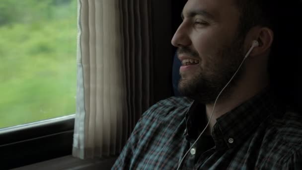 Jonge blanke man zingt zijn favoriete lied in een trein. — Stockvideo