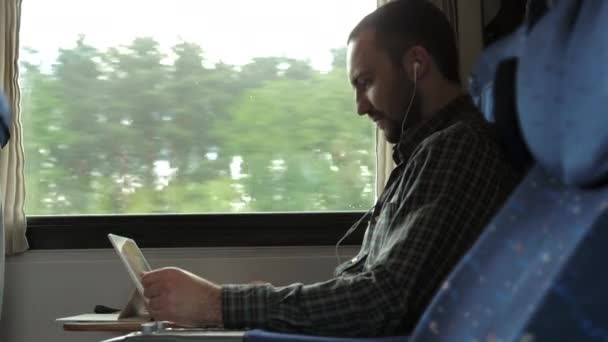 Homem sério assistindo notícias em um tablet em um trem. — Vídeo de Stock