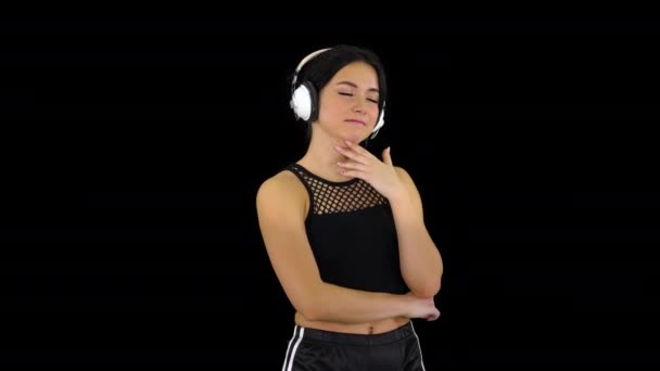 Junge sportliche schöne Frau genießt die Musik in Kopfhörer, Alpha-Kanal — Stockvideo