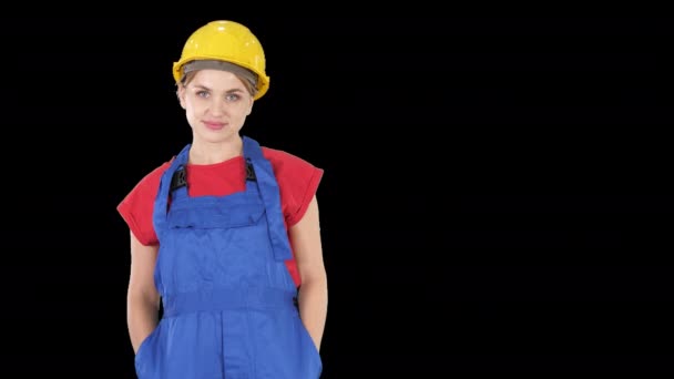 Mulher trabalhadora construtora sorridente em pé e mudando poses Dobre as mãos, mãos nos quadris, mãos nos bolsos, Canal Alpha — Vídeo de Stock