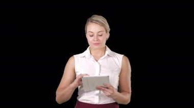 Güzel bir kız elinde tablet dokunmatik bilgisayarla sayfaları karıştırıyor ve kameraya bakıyor, Alfa Kanalı.