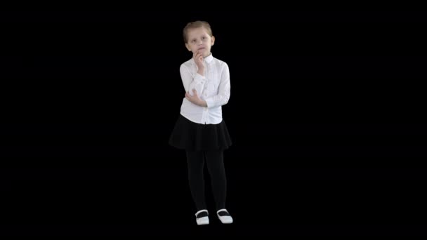 En nyfiken liten flicka står och tänker, alfakanal — Stockvideo