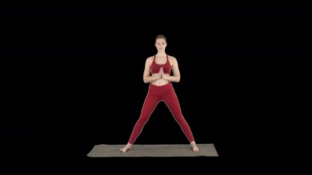 Atrakcyjna kobieta młody jogin praktykowania jogi concept, stojąc w Utthita parsvakonasana ćwiczeń, kanał alfa — Wideo stockowe