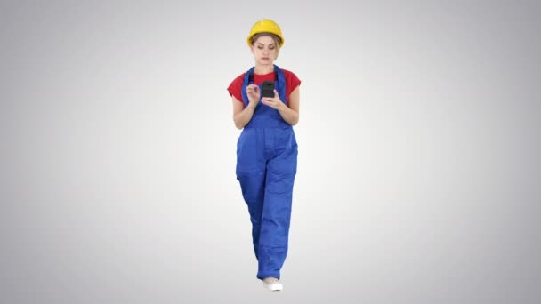 Женщина-работница ходит и использует телефон на градиентном фоне. — стоковое видео