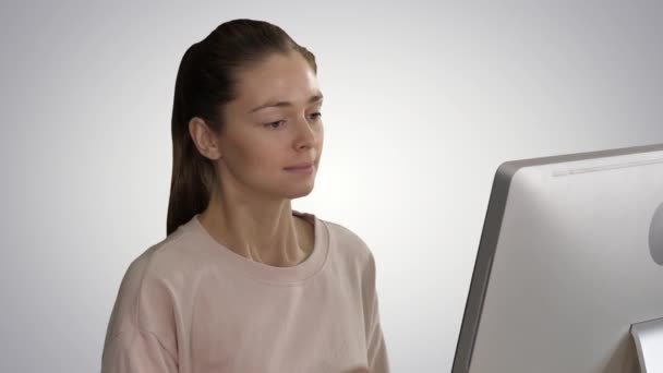 Κουρασμένη χαριτωμένο περιστασιακή γυναίκα στον υπολογιστή της σε ντεγκραντέ φόντο. — Αρχείο Βίντεο