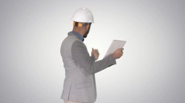 Hipster mühendisi gradyan arkaplan üzerine yaptığı çalışmaların sonucunu gösteren tabletle video görüşmesi yapıyor..