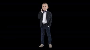 Sevimli küçük çocuk onun akıllı telefon konuşuyor ve koyu bir takım elbise, Alpha Channel ayakta