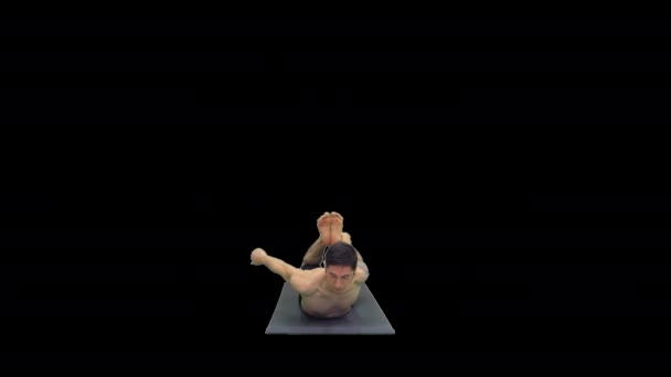 Shirtless athletic man demonstrates a yoga bow pose on mat, Alpha Channel — Stock Video