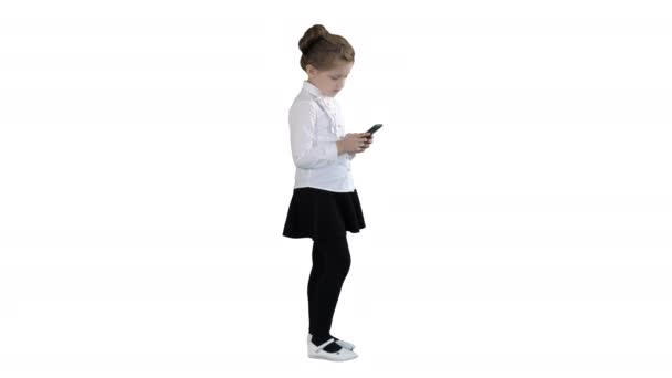 Petite fille utilisant un téléphone intelligent cellulaire sur fond blanc . — Video