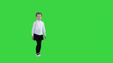 Sevimli küçük kız gülümseyen ve güvenle Yeşil Ekranda kameraya konuşurken, Chroma Key.