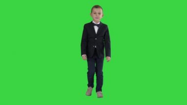 Yeşil Ekranda yürüyen papyonlu kostümlü küçük çocuk, Chroma Key.