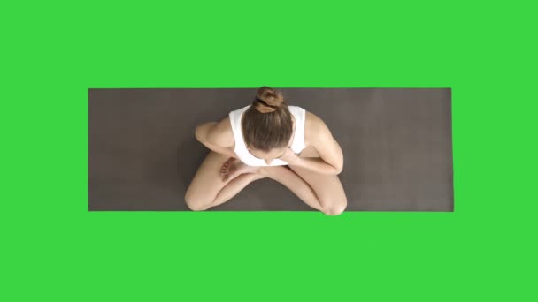 Yoga-Mädchen atmet in Lotus-Pose mit den Händen auf Bauch und Brust auf einem grünen Bildschirm, Chroma-Schlüssel. — Stockvideo