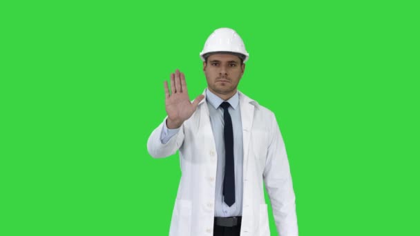 Science Engineer in helm toont stop Sing en maakt vervolgens een attentie gebaar op een groen scherm, Chroma Key. — Stockvideo