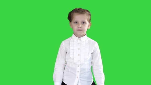 Pequena menina séria caminhando em direção à câmera em uma tela verde, Chroma Key . — Vídeo de Stock