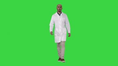 Yeşil Ekranda kameraya bakarak dolaşan ve konuşan dost canlısı erkek doktor, Chroma Key.
