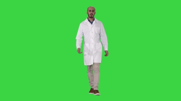 Friendly male doctor walking and talking looking in camera on a Green Screen, Chroma Key. — Stock Video