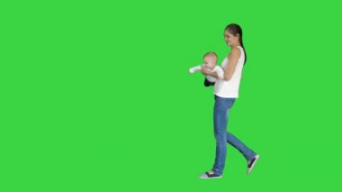 Anne elleri üzerinde bebeğini döndürür Bebek yeşil ekranda annelerin elinde uçan, Chroma Anahtar.