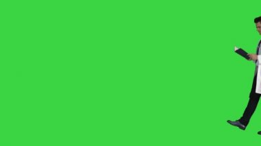 Yeşil Ekranda yürürken konsantre tıp doktoru okuma belgeleri, Chroma Key.