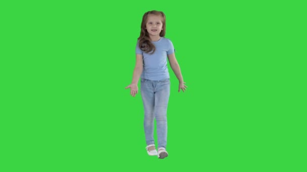 Όμορφο κορίτσι γελάει και χορεύει ενώ περπατάει σε μια πράσινη οθόνη, πλήκτρο αποχρώσεων. — Αρχείο Βίντεο