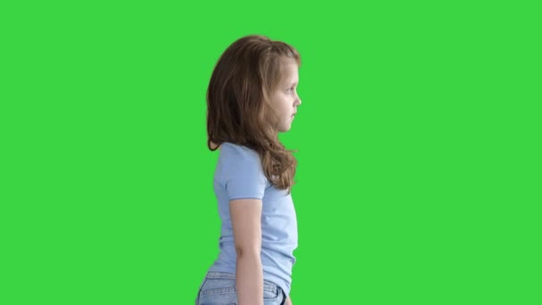 Schattig schoolmeisje wandelen met tassen in handen op een groen scherm, Chroma Key. — Stockvideo