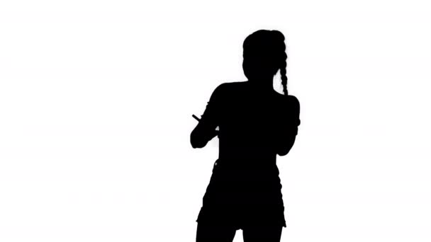 Silhouette Positive Pretty сексуальна дівчина слухає музику на своєму телефоні . — стокове відео