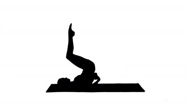 Silueta Mujer practicando yoga, de pie en salamba sarvangasana ejercicio, soporte de hombro pose. — Vídeo de stock
