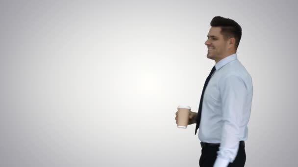 Zakenman wandelen met take-away koffie en papieren zak met lunch op gradiënt achtergrond. — Stockvideo
