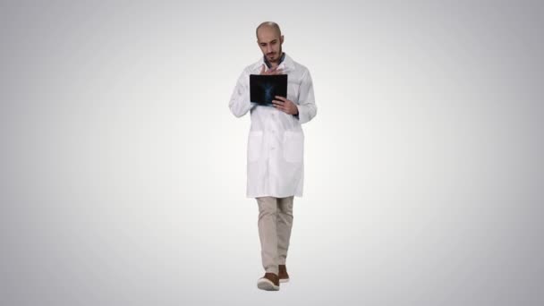 Läkare undersöker en lung radiografi medan promenader på gradient bakgrund. — Stockvideo