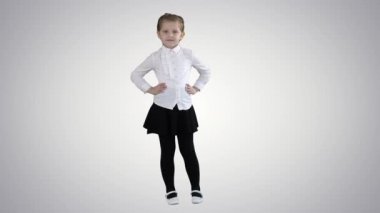 Beyaz elbiseli sevimli küçük kız degrade arka planda kamera poz.