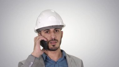 Mühendis degrade arka plan üzerinde vinç inşaat çalışmaları teftiş bir cep telefonu konuşuyor.