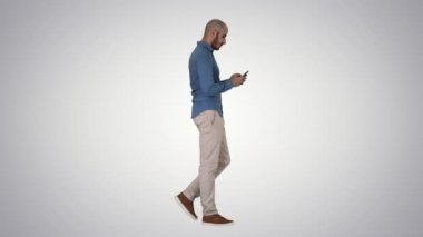 Genç adam yürüyor ve gradyan arka planda bir telefon kullanıyor..