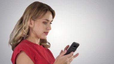 Ortamı tarayan ya da gradyan arkaplan üzerinde cep telefonuyla mesajlaşan mutlu kadın.