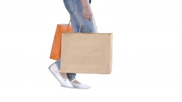 Alegre chica de la escuela caminando con bolsas de compras sobre fondo blanco . — Vídeo de stock